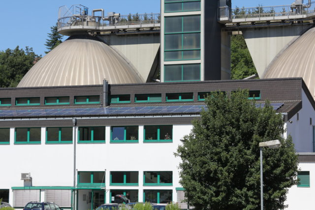 Kläranlage Kohlfurth, Betriebsgebäude mit Photovoltaik und dahinter die Faulbehälter